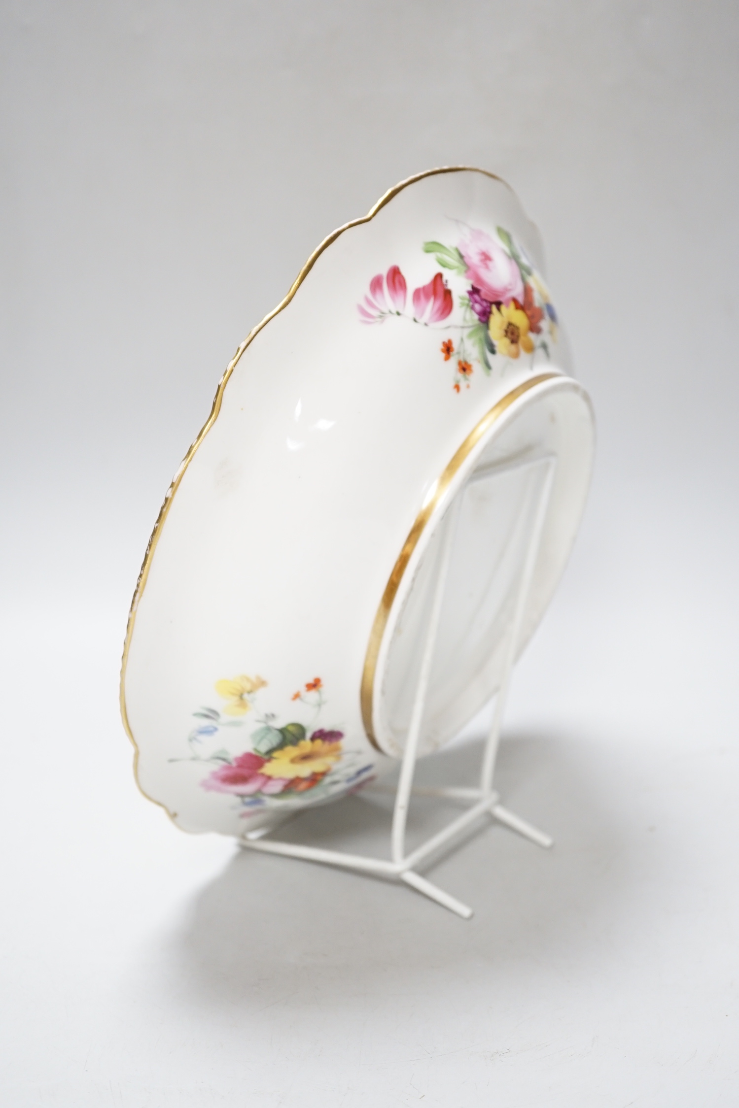 An English porcelain large bowl the centre painted with a bouquet of flowers under a green border with four ornately gilded designs, c.1820, 28cms diameter
